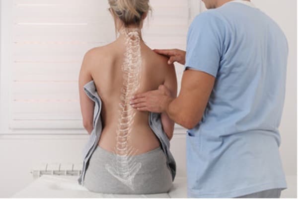 Image of doctor examining a womens back.